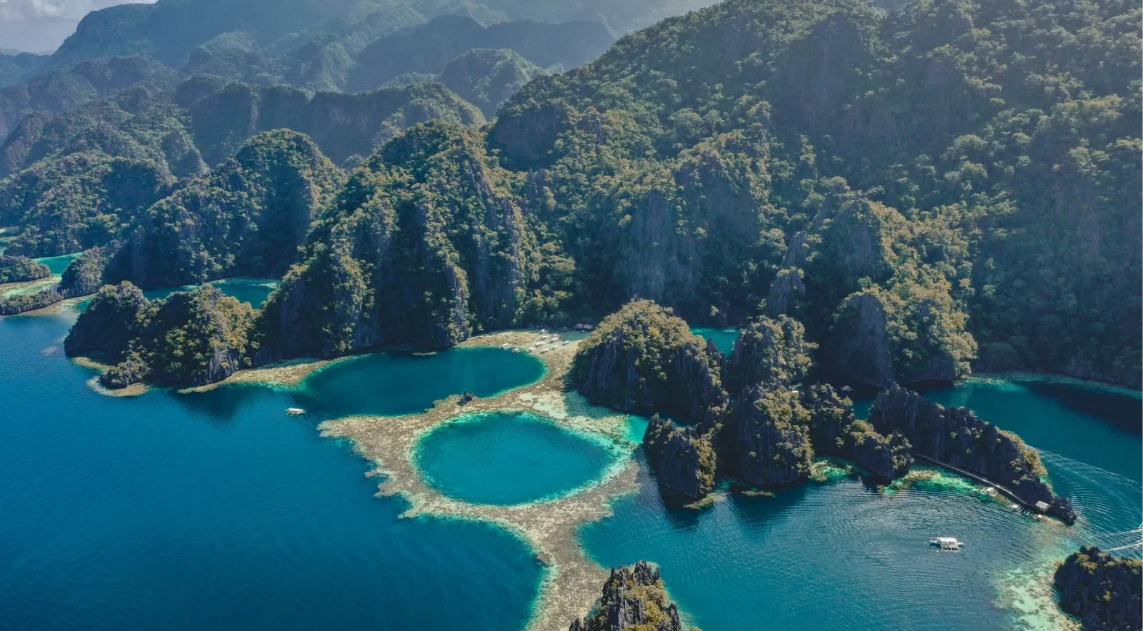 Aerial view of Coron's twin lagoons surrounded by dramatic limestone karst cliffs, Palawan